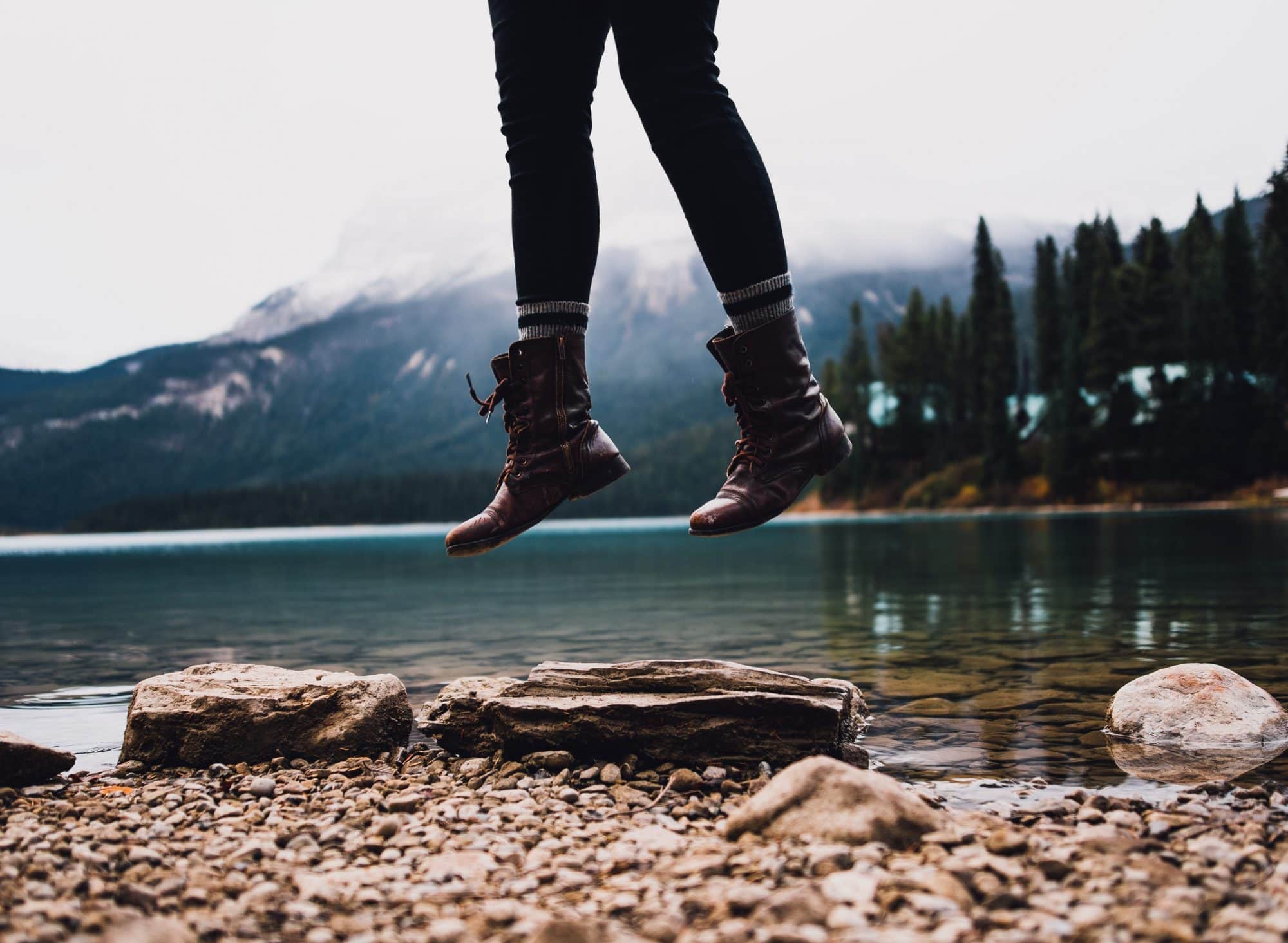 Person jumping next to a lake
