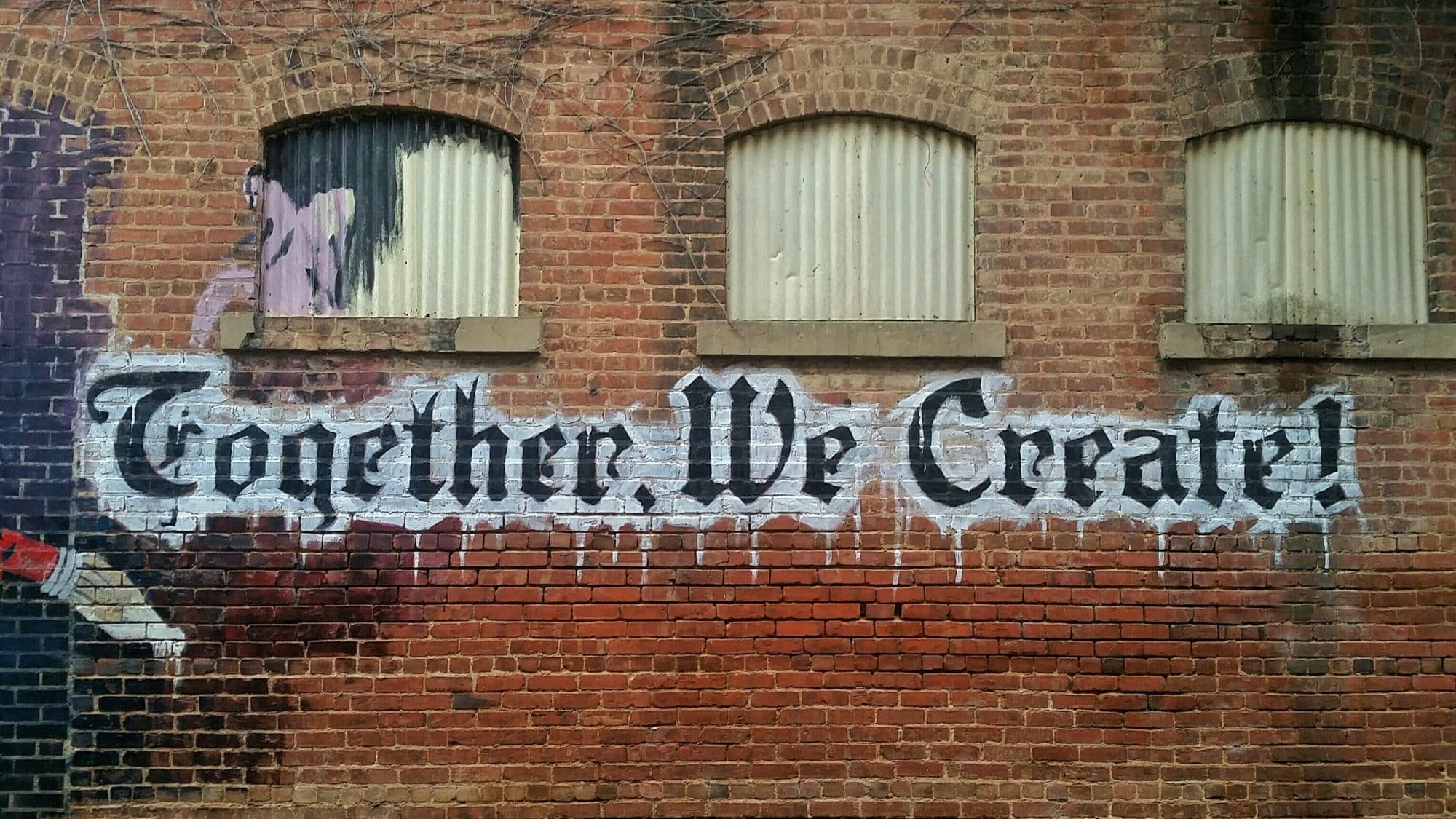 graffiti on bricks saying together we create