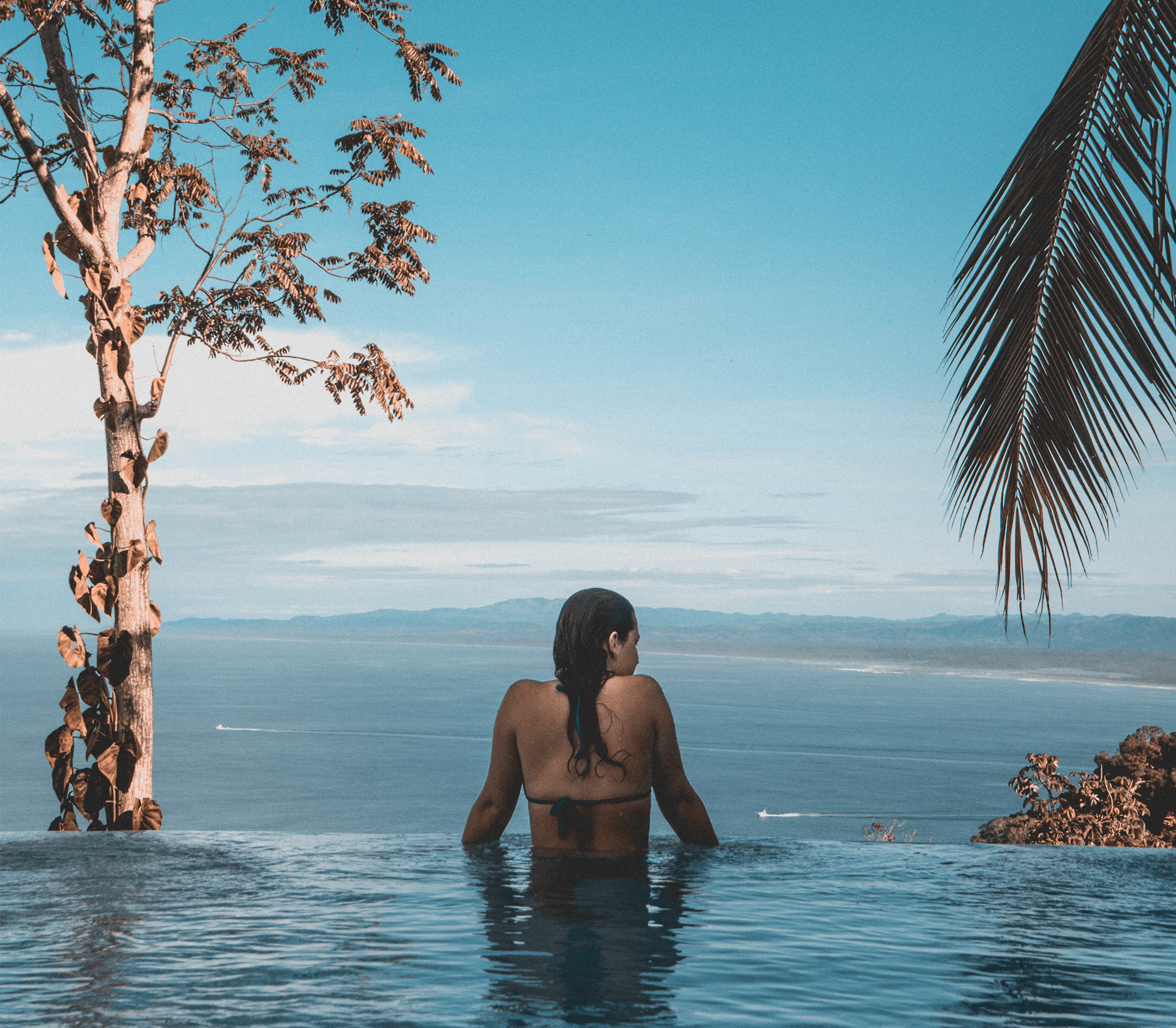 Woman in pool overlooking ocean